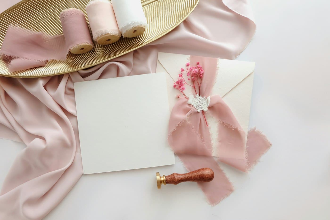 Wedding invitation card and envelope tied with blush ribbon